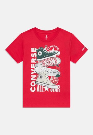 Rode katoenen T-shirt met een grafisch ontwerp van vier Converse sneakers in groene, witte en rode kleuren met kersen, en de tekst "CONVERSE ALL STAR".