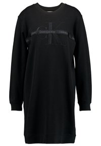 Musta college-mekko pitkillä hihoilla, pyöreällä kaula-aukolla ja ribbatut hihansuut. Ominaisuuksiin kuuluu kohotettu logo ja nauha, jossa on "CALVIN KLEIN JEANS" samassa värissä.