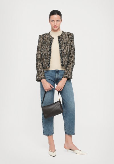 Tweed jasje met rafelige randen, beige trui, blauwe straight-leg jeans en zwarte handtas. Puntige witte slingback schoenen maken de outfit compleet.