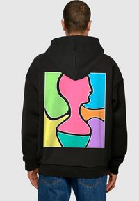 Schwarzer Hoodie mit einem großen, bunten geometrischen Design auf dem Rücken, mit pinken, grünen, blauen, orangefarbenen und lila Formen, die in Schwarz umrandet sind.