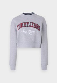 Felpa grigia a maniche lunghe con collo e polsini a costine. Presenta "TOMMY JEANS" in tartan rosso e "New York" in ricamo bianco. Tessuto morbido.