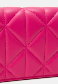 Quilted pink leather wallet featuring a geometric diamond pattern and contrasting stitching, emphasizing its smooth texture and vibrant color.