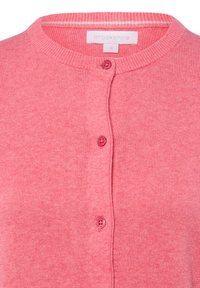 Cardigan rose en maille douce. Doté d'un col rond et de quatre boutons roses sur le devant. Étiquette visible avec le nom de la marque.