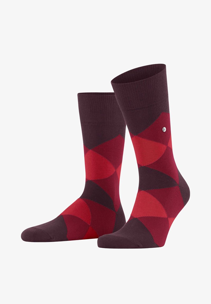 Chaussettes en coton rouges et bordeaux présentant un motif géométrique de cercles superposés, une bordure côtelée et un petit logo sur le côté.