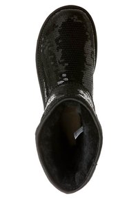 Bota negra hasta el tobillo con exterior de lentejuelas, puntera redonda, forro suave de piel y suela plana. El interior tiene una etiqueta en el lateral.