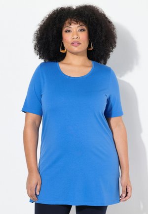 Camisa tunic de manga corta en color azul, fabricada en una tela suave; presenta un escote redondo y un corte relajado que se extiende más allá de las caderas.