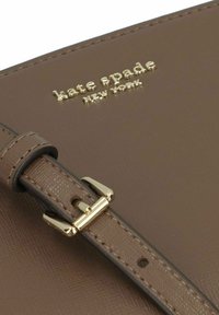 Borsa a tracolla in pelle marrone con finitura testurizzata, dotata di logo in tono oro, tracolla e chiusura in metallo lucido.