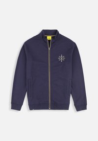 Sweatshirt zippé marine en tissu doux. Il présente un col haut, des poches latérales et un design brodé subtil sur la poitrine.