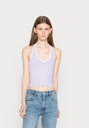 Top halter lilás com acabamento branco, apresentando um decote em V profundo e um design ajustado. Combinado com jeans de brim azul-claro de cintura alta.