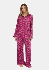 Langärmliges rosa Pyjama-Set mit verspieltem grauem Muster, bestehend aus einem Oberteil mit Kragen und passenden Hosen mit lockerem Sitz und weicher Textur.