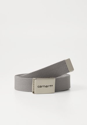 Cinturón de tela gris trenzada con hebilla metálica plateada. La hebilla presenta el logotipo "carhartt" grabado. Tejido texturizado con un diseño plano, adecuado para uso casual.