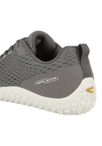 Grauer Sportschuh mit atmungsaktivem Mesh-Obermaterial, strukturiertem Paneel, weißem, gemustertem Außensohle und dezentem Logo-Detail.