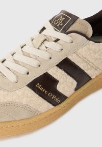Sneaker in suede e lana beige con strisce in pelle marrone, lacci crema, suola in gomma e marchio "Marc O'Polo" su etichetta in pelle e linguetta.