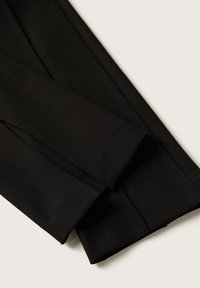 Černé přizpůsobené kalhoty s hladkou texturou, rovný střih a pečlivě zpracované švy, s ostrým, skládáním zakončeným lemem.