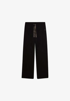 Pantaloni neri a gamba larga con vita elastica e coulisse con stampa leopardata su sfondo bianco.