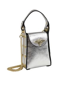 Sac à main en métal argenté avec des accents noirs, doté d'une poignée supérieure, d'une chaîne en bandoulière, d'étoiles dorées et d'un emblème décoratif en forme d'abeille sur le rabat.
