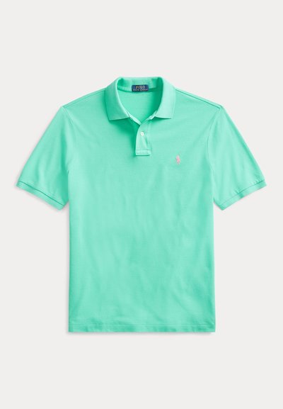 Zelené polo tričko s krátkym rukávom, dvoma gombíkmi a malým ružovým vyšívaným logom na ľavej strane hrudníka.