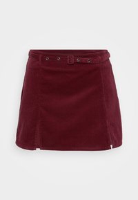 Bordeaux corduroyrok met een aansluitend ontwerp, inclusief een riem met metalen hardware, en heeft twee zijsplitten voor extra detail.