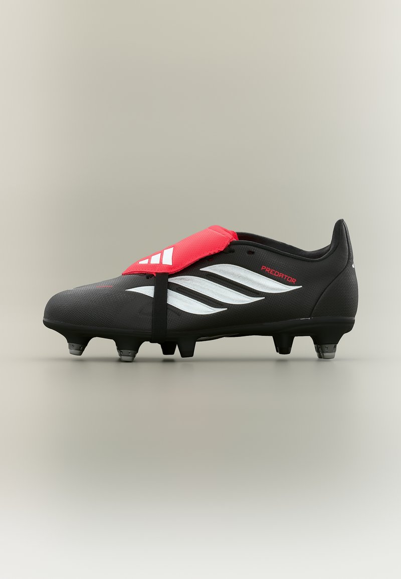 Μαύρο ποδοσφαιρικό παπούτσι Adidas Predator με λευκές ρίγες, κόκκινο κάλυμμα κορδονιών και καλουπωμένα τρακτέρ σε ανοιχτό φόντο.