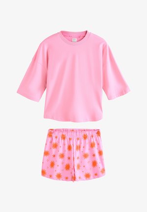 Vaaleanpunainen lyhythihainen paita yhdistetty vaaleanpunaisiin kuminauhakuminauhavyötäröisiin shortseihin, joissa on oranssi aurinko- ja tähtikuvio.