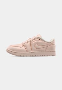 Baskets Nike en matériau rose doux avec une texture lisse. Design bas classique, présentant des accents blancs et un motif de semelle en caoutchouc.