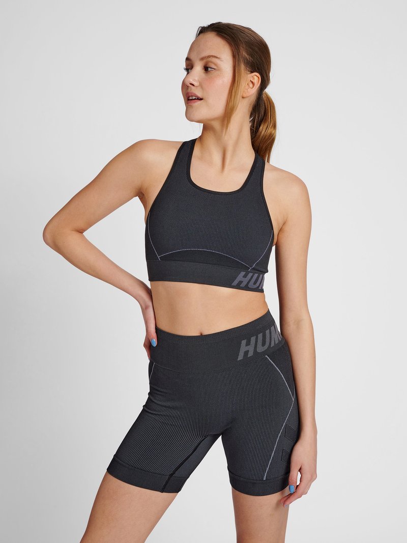 Schwarzes Sport-Set mit einem gerippten Sport-BH und passenden hochgeschnittenen Shorts, mit kontrastierenden Nähten und Logodetails am Bund.