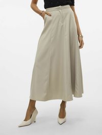 Beige, hög midja maxi kjol med veck, sidofickor och slät yta. Matchad med krämfärgade spetsiga klackskor.