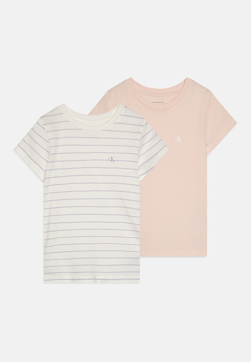 Two short-sleeve t-shirts: one in cream with purple stripes and a logo, the other in solid pastel pink with a logo. Soft cotton fabric.