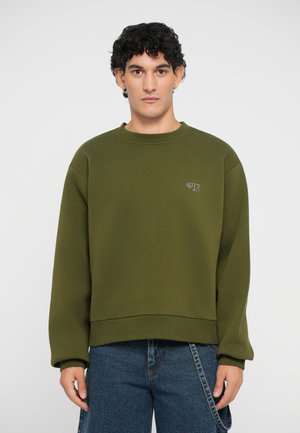 Olivenfarget sweatshirt i avslappet passform, med rund hals og ribbestrikkede mansjetter. Liten brodert detalj på brystet.