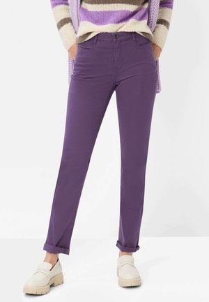 Purple cotton pants with a straight-leg design. Rolled cuffs and front pockets. Lightweight fabric paired with cream slip-on shoes.