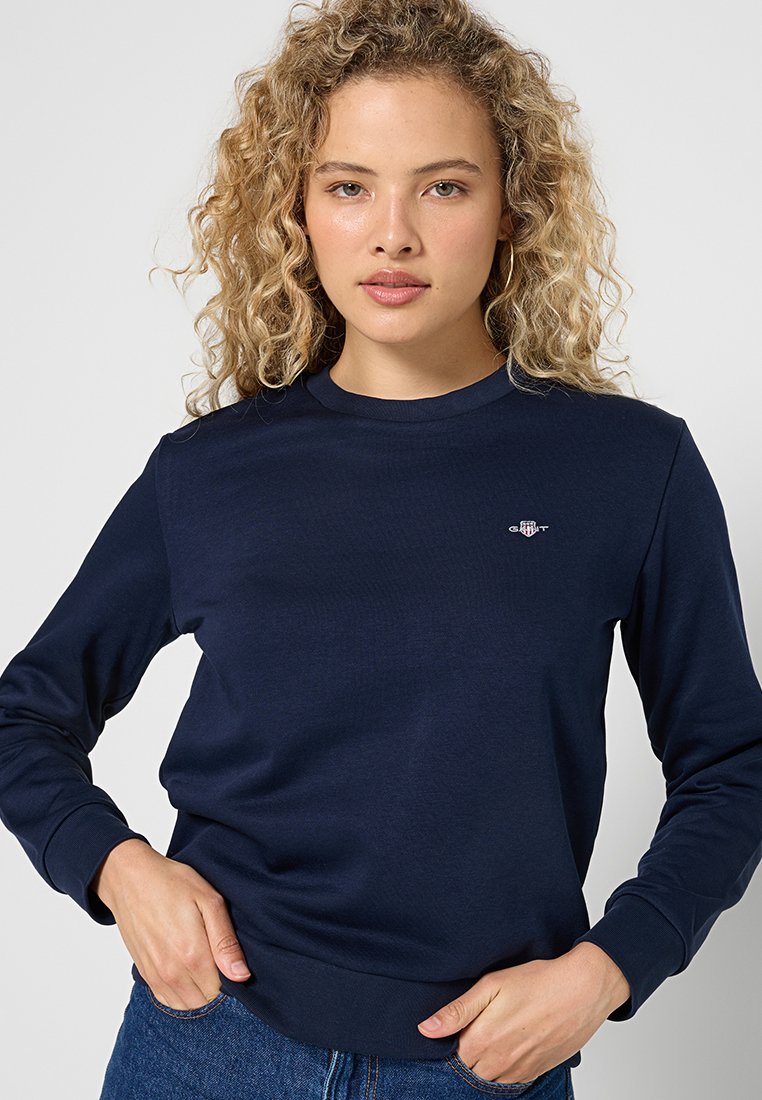 Navyblaues Langarm-Sweatshirt aus Baumwolle, mit Rundhalsausschnitt und kleinem Logo auf der Brust, mit einer glatten Textur und bequemer Passform.