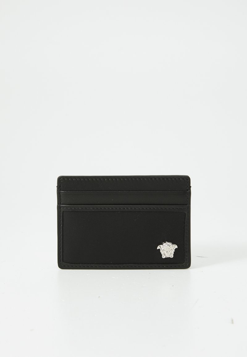 Must nahast kaarditasku, millel on kolm kaardipesa ja väike hõbedane Meduusa pea embleem alumises paremas nurgas.