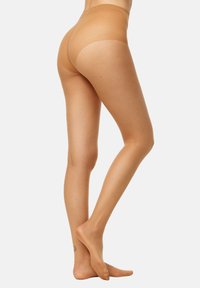 Medias transparentes sin costura de textura suave, con una cinturilla alta que proporciona un aspecto de tono de piel uniforme en las piernas.