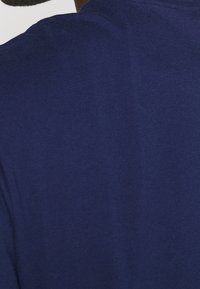 Navy blue t-shirt made from soft cotton, featuring a crew neckline and a smooth, plain texture with no visible patterns or accents.