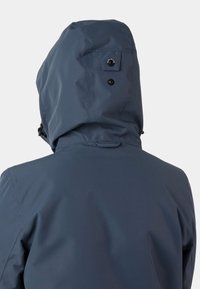 Mörkblå vattentät jacka med huva, med tryckknappsdetaljer och en jämn, matt textur. Inga synliga mönster.