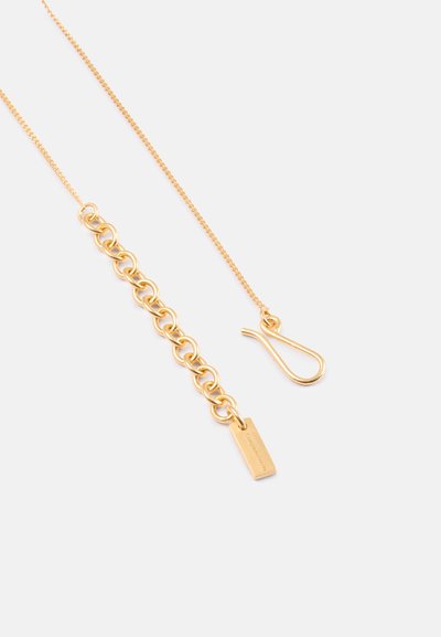 Χρυσή αλυσίδα κολιέ με υφή που διαθέτει σχέδιο αλυσιδωτού κρίκου, ορθογώνια ετικέτα και κλείσιμο με γάντζο.