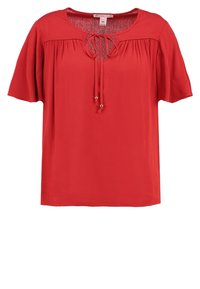 Blouse rouge à manches courtes en tissu léger, avec un col rond et un détail à nouer, ainsi que des plis subtils sur la poitrine.