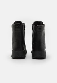 Svarta ankelskor i slät läder, med en elegant design, rundade tår och dubbla siddragkedjor för enkel påtagning. Strukturerad sula för bra grepp.