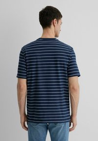 Navy blue short-sleeve T-shirt with horizontal white stripes, round neckline, and a relaxed fit. Fabric appears soft with a smooth texture.