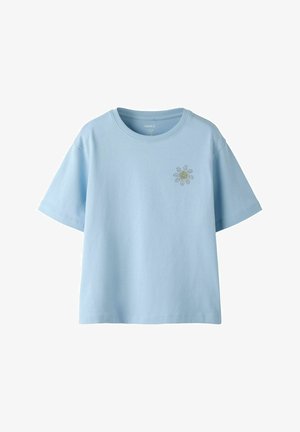 Jasnoniebieski t-shirt z krótkim rękawem, z małą grafiką stokrotki na lewej piersi, z okrągłym dekoltem i luźnym krojem.