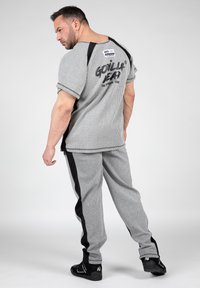 Grijs gestreept shirt met korte mouwen, met een ontwerp met zwarte accenten, gecombineerd met bijpassende sweatpants met zijstrepen en een gestructureerde afwerking.