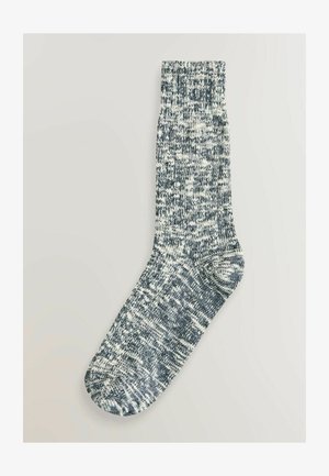 Tumeda sokk tume sinise ja valge kirju mustriga, ribaga varruga ja tekstuuriga kangaga. Üksikasjalik pere pikkuse disain.