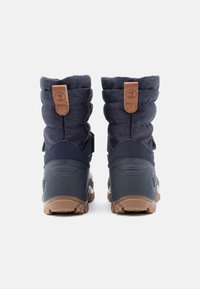 Wodoodporne granatowe zimowe buty z wyściełanym kołnierzem z tkaniny, brązowymi skórzanymi akcentami, gumową podeszwą i trwałym teksturowanym gripem. Widok z tyłu pokazuje wysokość i design.