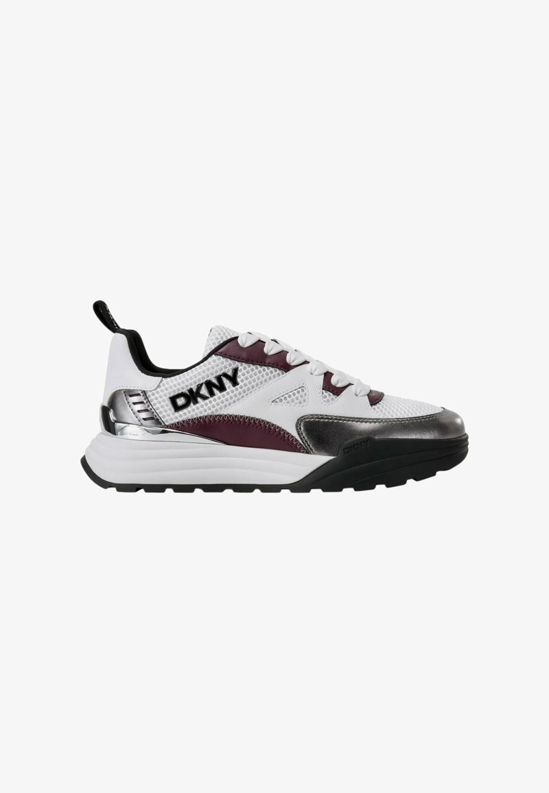 Baskets blanches en tissu mesh, avec accents violets et détails métalliques argentés. Semelle extérieure noire et logo "DKNY" bien visible sur le côté.