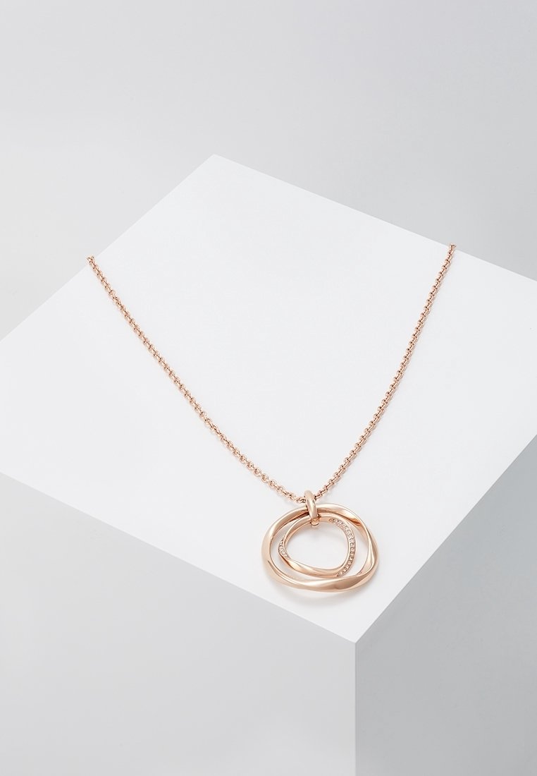 Collier chaîne en or rose avec deux pendentifs circulaires entrelacés, l'un lisse et l'autre incrusté de petits cristaux, présenté sur une surface blanche.