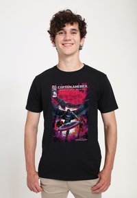 Camiseta de algodón negra con un vibrante estampado gráfico de Capitán América con un escudo, sobre un colorido fondo estilo cómic.