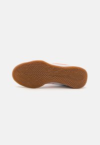 Sportlichen Schuhsohle aus Gummi mit einem strukturierten Grip-Muster. Farbe ist braun mit kontrastierenden weißen und orangefarbenen Akzenten an der Seite.