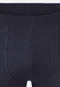 Boxer shorts en coton stretch bleu marine, dotés d'une ceinture élastique confortable et d'un design sans couture pour un ajustement agréable.