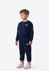 Unisex mørkeblå genser og joggebukser sett fra The North Face, med logo-detaljer, ribbestrikkede mansjetter og en avslappet passform.