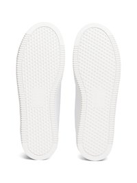 Weiße Sneaker-Sohlen mit einer strukturierten GummOberfläche, die ein Diamantmuster für besseren Halt und einen glatten Rand aufweisen.